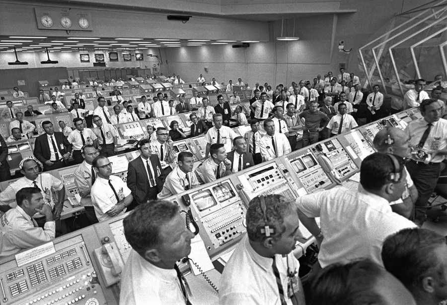July 16, 1969 - Members of the Kennedy Space Center government-industry team rise from their consoles within the Launch Control Center to watch the Apollo 11 liftoff through the large windows at the back of the firing room. Among those pictured is American aerospace engineer JoAnn H. Morgan (seated center, with hand on chin) who, at the time, was NASA's only female engineer.